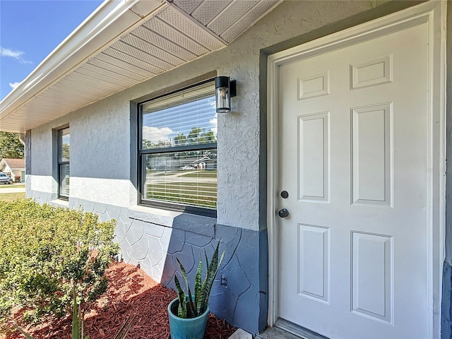 view of exterior entry with stucco siding