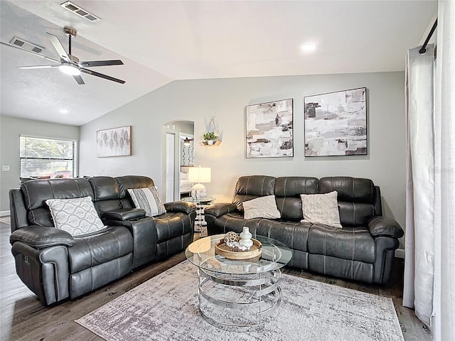 living room with wood finished floors, visible vents, arched walkways, ceiling fan, and vaulted ceiling