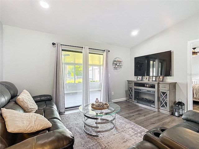 living area featuring lofted ceiling, recessed lighting, wood finished floors, and baseboards