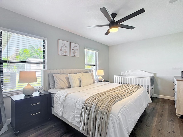 bedroom featuring baseboards, dark wood-type flooring, and ceiling fan