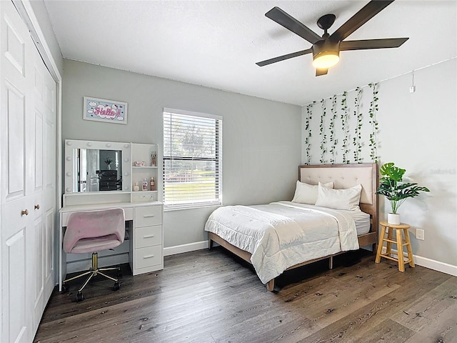 bedroom featuring dark wood finished floors, baseboards, a closet, and ceiling fan