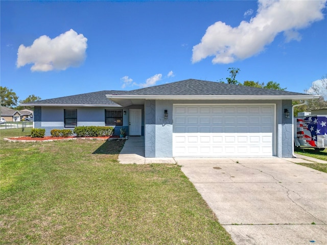 ranch-style house with a front yard, concrete driveway, an attached garage, and stucco siding