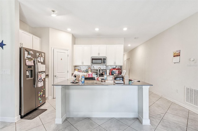 kitchen with appliances with stainless steel finishes, backsplash, visible vents, and white cabinetry