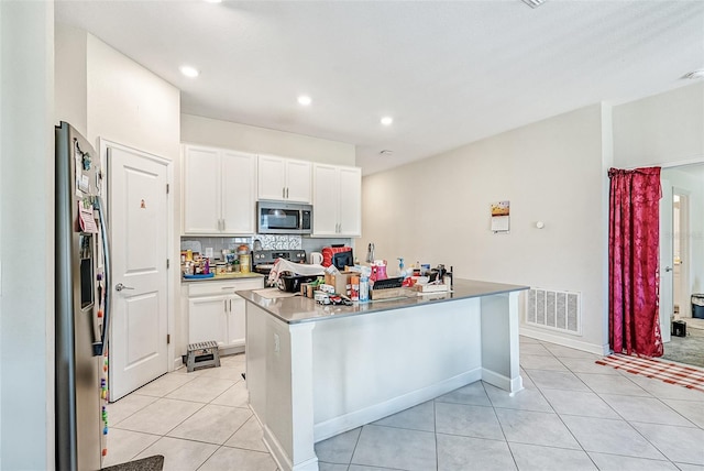 kitchen featuring light tile patterned floors, visible vents, decorative backsplash, appliances with stainless steel finishes, and white cabinetry