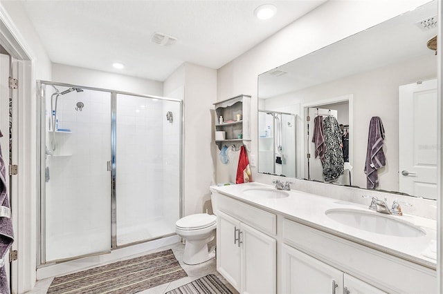 full bath featuring double vanity, a stall shower, toilet, and a sink