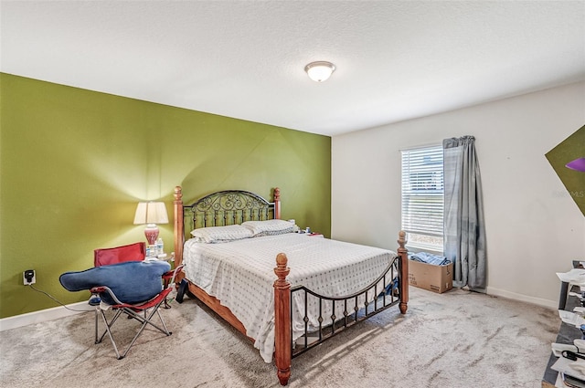 bedroom with a textured ceiling, carpet flooring, and baseboards