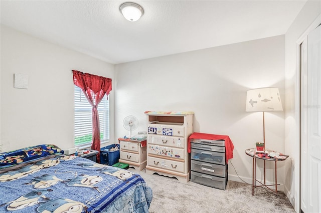 carpeted bedroom with a textured ceiling and baseboards