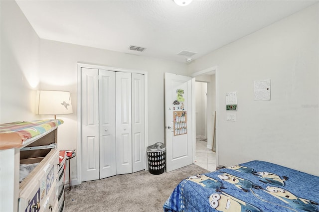 bedroom with light carpet, a closet, and visible vents