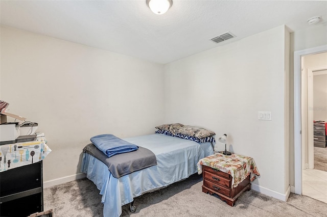 carpeted bedroom featuring visible vents and baseboards