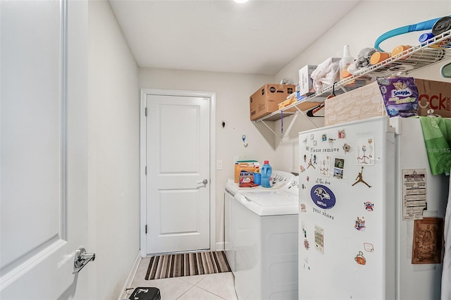 washroom featuring laundry area, tile patterned floors, baseboards, and independent washer and dryer