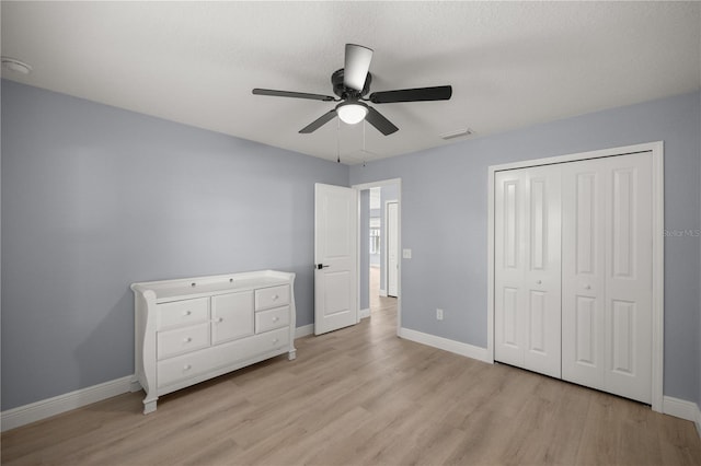 unfurnished bedroom with visible vents, baseboards, a ceiling fan, light wood-style floors, and a closet