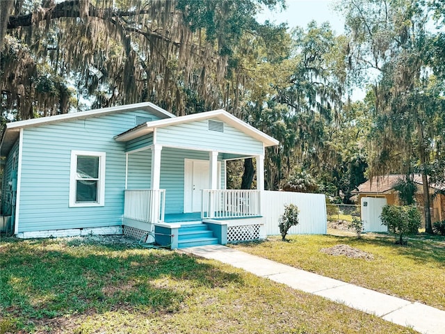 view of front of house featuring covered porch and a front lawn