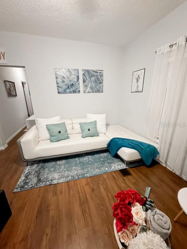 living room with a textured ceiling and wood finished floors