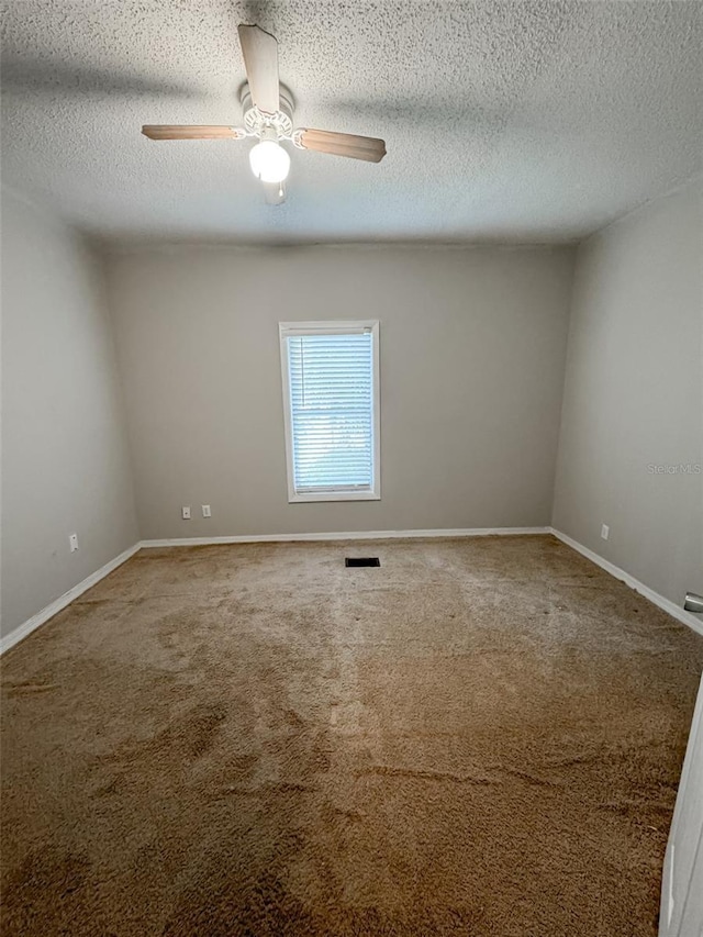 empty room featuring visible vents, baseboards, ceiling fan, carpet, and a textured ceiling