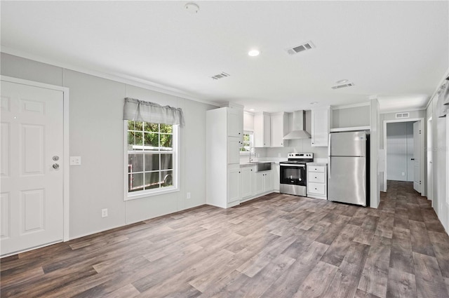 kitchen with white cabinetry, wall chimney exhaust hood, visible vents, and appliances with stainless steel finishes