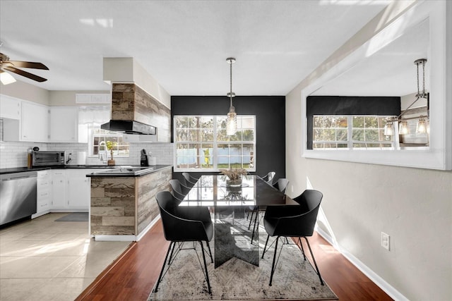 dining area with a toaster, baseboards, light wood-style floors, and ceiling fan