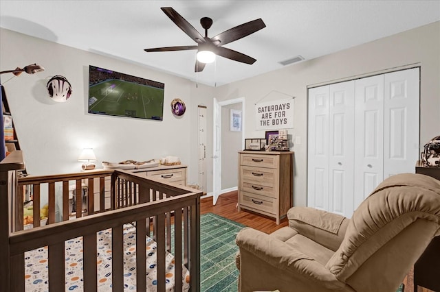 bedroom with visible vents, baseboards, wood finished floors, a closet, and a ceiling fan