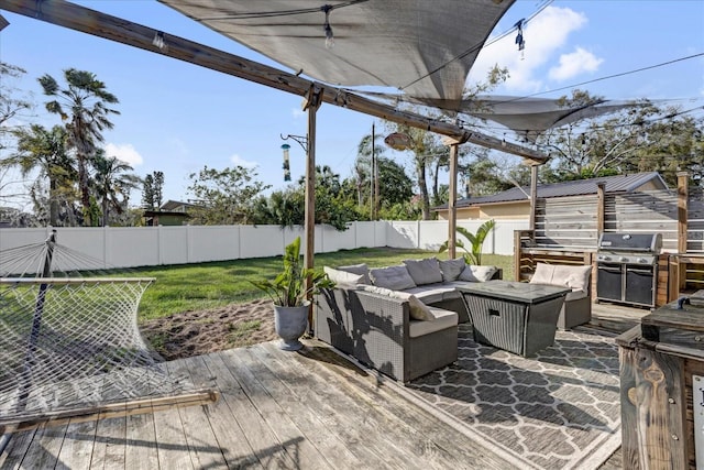 wooden deck with outdoor lounge area, a yard, a fenced backyard, and grilling area