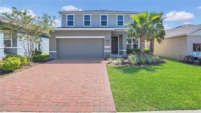 view of front of property featuring a front yard, decorative driveway, an attached garage, and stucco siding