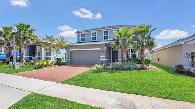 view of front of house with decorative driveway, a garage, a front yard, and stucco siding