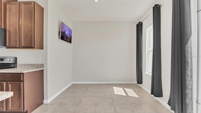 interior space with light tile patterned floors and baseboards