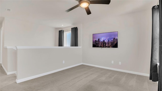 carpeted empty room featuring baseboards and ceiling fan