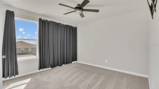 empty room featuring carpet flooring, a ceiling fan, and baseboards