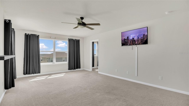 empty room featuring baseboards, ceiling fan, and carpet floors