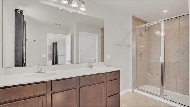 bathroom with double vanity, a stall shower, visible vents, and a sink