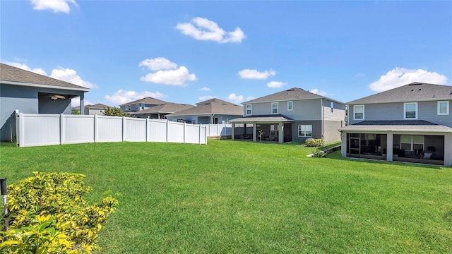 view of yard with fence, a residential view, and a sunroom