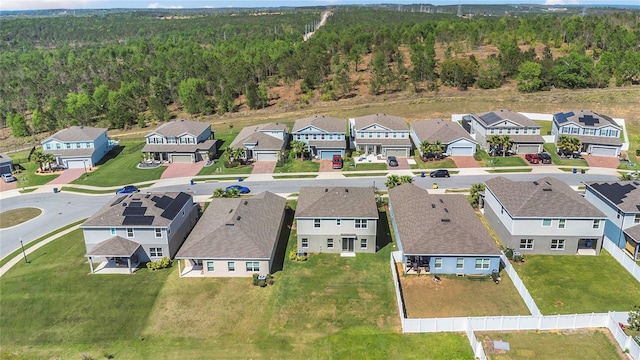 drone / aerial view featuring a residential view and a view of trees