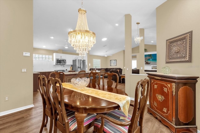 dining room with a chandelier, light wood finished floors, baseboards, recessed lighting, and lofted ceiling