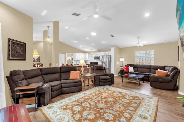 living room with visible vents, light wood-style floors, and a ceiling fan