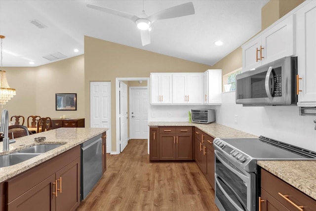 kitchen featuring vaulted ceiling, visible vents, a sink, and stainless steel appliances