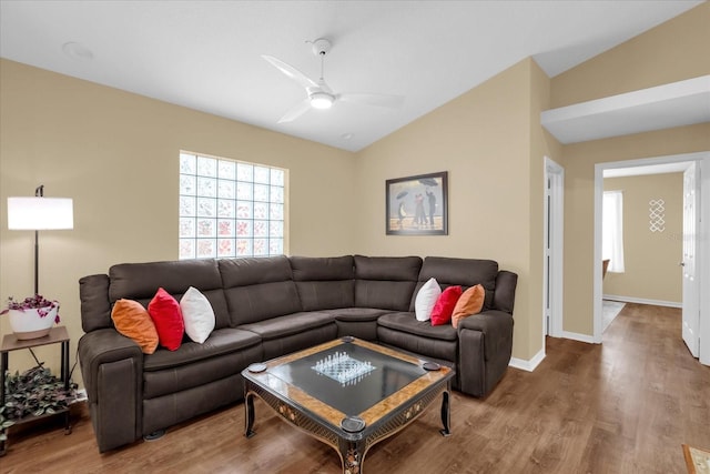 living room with baseboards, vaulted ceiling, wood finished floors, and a ceiling fan