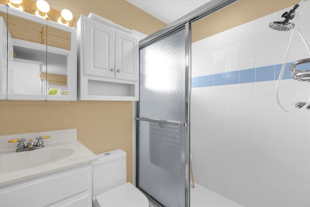 bathroom featuring vanity, toilet, and a shower stall