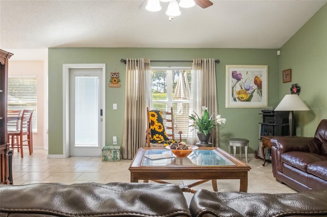 living area with light tile patterned floors and ceiling fan