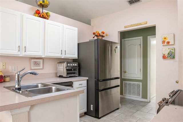 kitchen featuring visible vents, appliances with stainless steel finishes, light countertops, and a sink