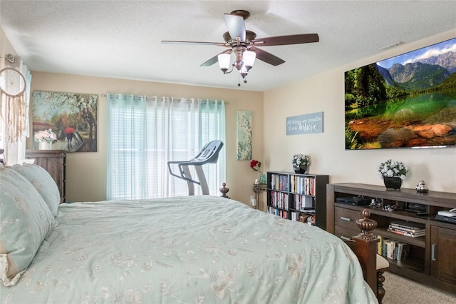 bedroom featuring a textured ceiling, visible vents, and ceiling fan