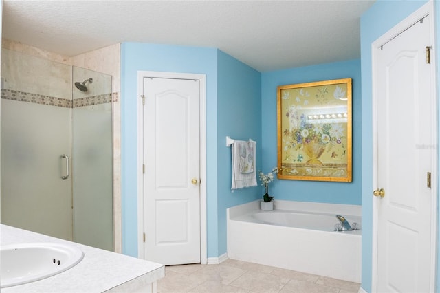 full bath with tile patterned floors, a garden tub, a textured ceiling, a shower stall, and vanity