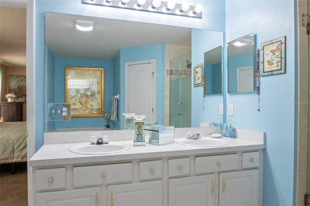 ensuite bathroom with double vanity, a shower stall, ensuite bath, and a sink