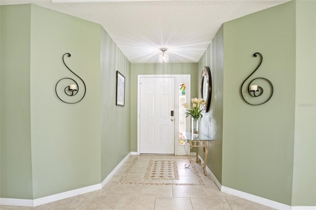 entrance foyer with light tile patterned floors, baseboards, and a textured ceiling