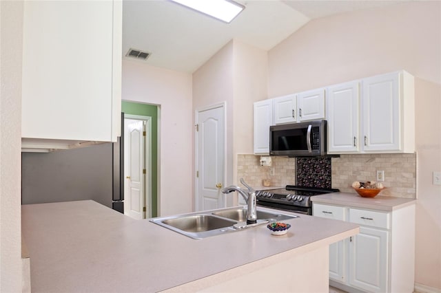 kitchen with a sink, white cabinets, light countertops, tasteful backsplash, and appliances with stainless steel finishes
