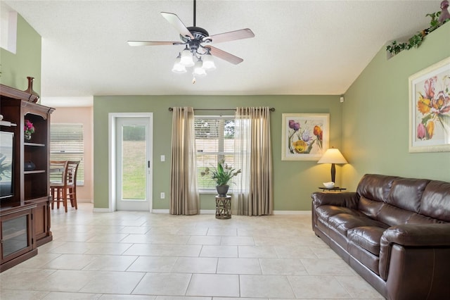 living area with ceiling fan, baseboards, and light tile patterned floors
