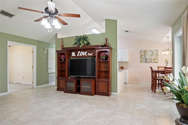 living room featuring vaulted ceiling, ceiling fan with notable chandelier, baseboards, and visible vents