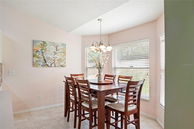 dining area with baseboards, an inviting chandelier, light tile patterned floors, and a textured ceiling