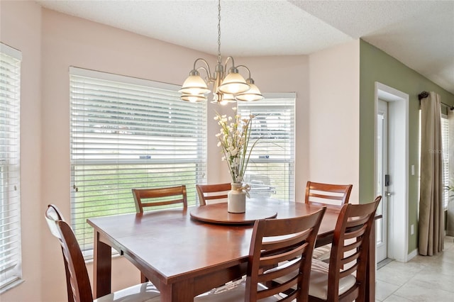 dining room featuring a notable chandelier, light tile patterned flooring, and a textured ceiling