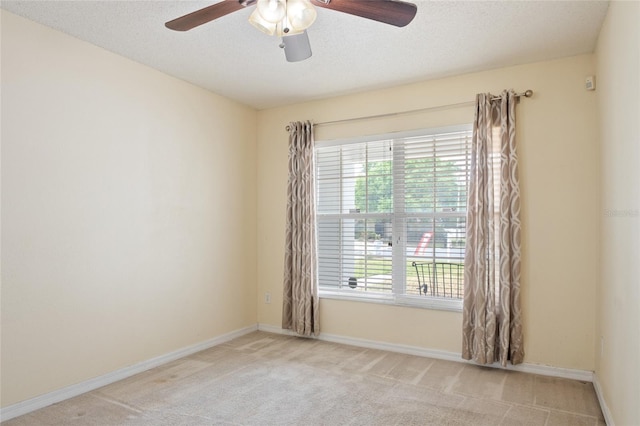 empty room featuring ceiling fan, a textured ceiling, carpet, and baseboards