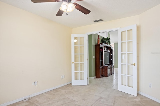 unfurnished room with french doors, a ceiling fan, carpet floors, visible vents, and baseboards