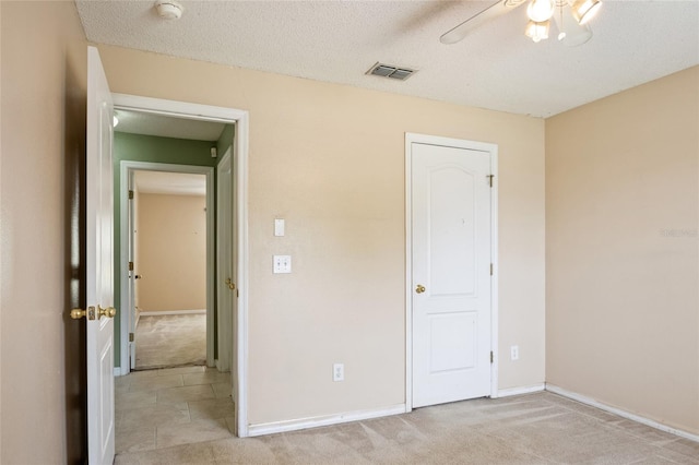 unfurnished bedroom with baseboards, ceiling fan, light carpet, and visible vents